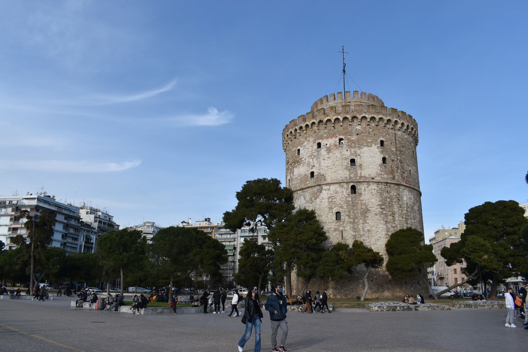 Der Weiße Turm von Thessaloniki unter blauem Himmel, Spaziergänger auf der Uferpromenade